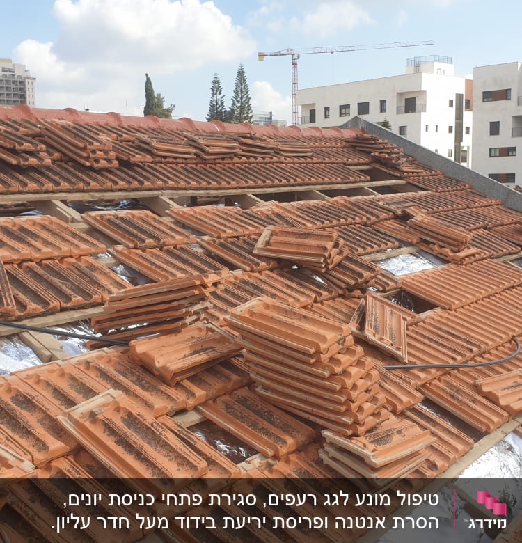 רעפים כתומים מונחים על גג בתהליך בנייה